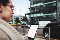 Junge Frau fährt mit digitalem Tablet gegen Straße — Stockfoto