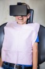 Menino usando fone de ouvido de realidade virtual durante uma consulta odontológica na clínica — Fotografia de Stock