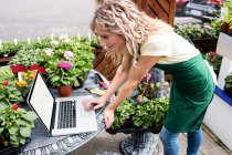 Female florist using laptop in garden centre — Stock Photo