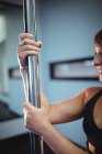 Pole-Tänzerin hält Pole im Fitnessstudio — Stockfoto