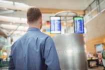 Rear view of man standing in airport terminal — Stock Photo