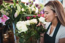 Floristin riecht Blume in ihrem Blumenladen — Stockfoto