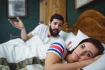 Пара спорящих на кровати в спальне дома — стоковое фото