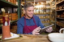 Male potter using digital tablet in pottery workshop — Stock Photo