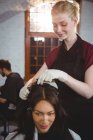 Hairdresser styling customer hair in salon — Stock Photo