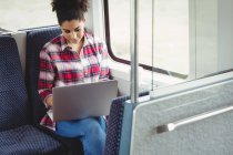 Mulher com laptop enquanto está sentado no trem — Fotografia de Stock