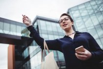 Low angle view of businesswoman gesturing outside office building — Stock Photo