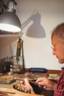 Фокусированный ювелир готовит кольцо в мастерской — стоковое фото
