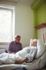 Hombre mayor consolando a mujer mayor en el hospital - foto de stock