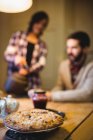 Close-up of cookie on a table at home with couple in background — Stock Photo