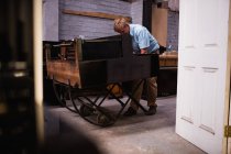 Técnico de piano reparando piano vintage en taller - foto de stock