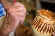 Image recadrée de la peinture de potier sur bol en atelier de poterie — Photo de stock
