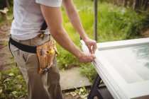 Midsection of carpenter preparing frame of door on lawn — Stock Photo
