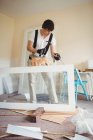 Bonito carpinteiro trabalhando na porta de madeira em casa — Fotografia de Stock