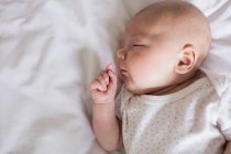 Baby sleeping on bed in bedroom at home — Stock Photo