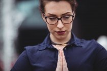 Primer plano de la mujer de negocios con las manos cerradas rezando - foto de stock