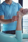 Обітнутого зображення чоловічого фізіотерапевт, даючи масаж ступень пацієнтки — стокове фото