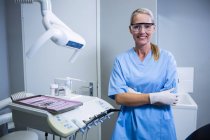 Усміхнений стоматолог-асистент із захисними окулярами в стоматологічній клініці — стокове фото