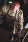 Portrait of welder standing near working tool in workshop — Stock Photo