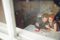 Пара с помощью цифровых таблеток видно из окна дома — стоковое фото