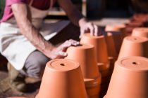 Immagine ritagliata di vasaio che conta vasi di fiori in laboratorio di ceramica — Foto stock
