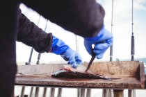 Обрезанное изображение рыбака, филе рыбы на лодке — стоковое фото