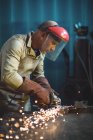 Saldatore maschio che lavora su un pezzo di metallo in officina — Foto stock