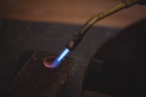 Close-up of ring being heated with burner in workshop — Stock Photo