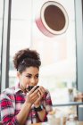 Giovane donna che beve caffè mentre è seduto al ristorante — Foto stock