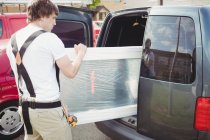 Carpenter taking out door from car — Stock Photo