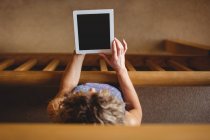Висока кут зору Жінка тримає цифровий планшетний в бібліотеці — стокове фото