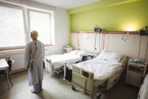 Senior mulher em pé na enfermaria do hospital — Fotografia de Stock