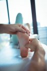 Imagem recortada de fisioterapeuta masculino dando massagem nos pés para paciente do sexo feminino na clínica — Fotografia de Stock
