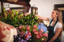 Florista feminino organizando flor na loja de flores — Fotografia de Stock