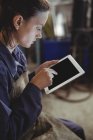 Saldatore femmina con tablet digitale in officina — Foto stock