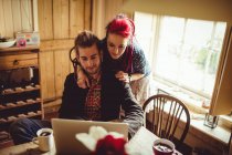 Smart couple using laptop at home — Stock Photo
