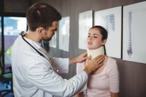Fisioterapeuta examinando paciente mujer cuello en clínica - foto de stock