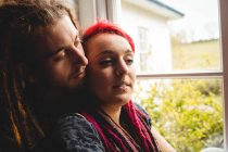 Romantic hipster couple by window at home — Stock Photo