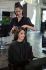 Smiling female getting her hair trimmed at salon — Stock Photo