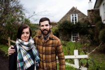 Portrait of happy couple standing with arms around in countryside — Stock Photo