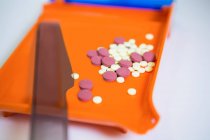 Крупный план различных таблеток на подносе в аптеке — стоковое фото
