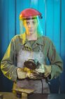 Portrait of female welder holding circular saw in workshop — Stock Photo
