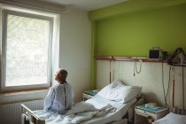 Продуманий старший чоловік сидить на ліжку в лікарні — стокове фото