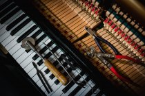 Close-up de ferramentas de reparação mantidos no teclado antigo piano — Fotografia de Stock