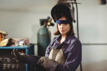 Portrait de femme soudeuse portant un gant en atelier — Photo de stock