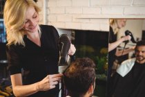 Усміхнений чоловік отримання його волосся сушать фен для волосся в салон — стокове фото