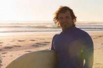 Surfista sorridente alla telecamera sulla spiaggia — Foto stock
