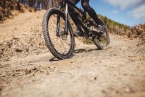 Partie basse du vélo roulant sur le chemin de terre à la montagne — Photo de stock