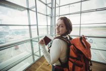 Porträt einer Frau mit Pass, die im Wartebereich des Flughafenterminals steht — Stockfoto