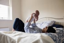 Mother playing with son in bedroom at home — Stock Photo